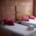 Hotel 74 Amsterdam room with two twin beds, red patterned wallpaper and window light