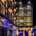 Hotel Nahar Nilgiris in Ooty at night, with lit facade and narrow street between buildings