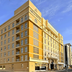 Asma Hotel Dubai exterior on a sunny street, featuring a yellow facade and arched entrance