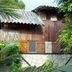 Hostal Oloncito in Olón, rustic wood-and-stone hotel exterior surrounded by lush tropical foliage