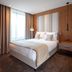 Titanic Chaussee Berlin guest room with a bed, window, and wood-paneled wall in Berlin