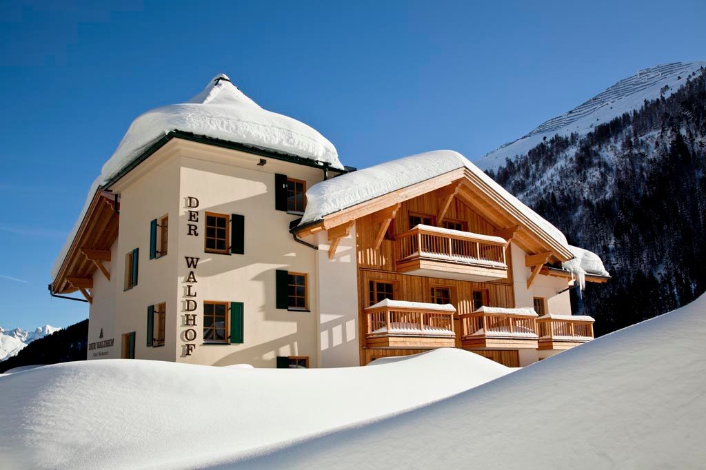 Der Waldhof in Sankt Anton am Arlberg, a snow-covered alpine hotel with wooden balconies and mountain backdrop