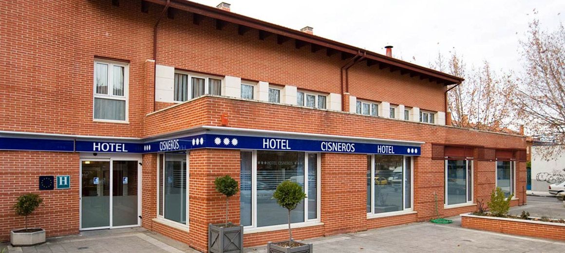 Partner Cisneros hotel in Madrid, brick exterior with blue awning and ground-floor entrance