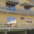 Pousada Bomar in Bombinhas, exterior view of a yellow hotel with balconies and glass doors