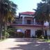 La Paradise Inn in Accra with a two-story white building, red roof, and palm-lined driveway