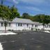 Bass River Motel in South Yarmouth, white motel exterior with pink shutters and a paved parking lot