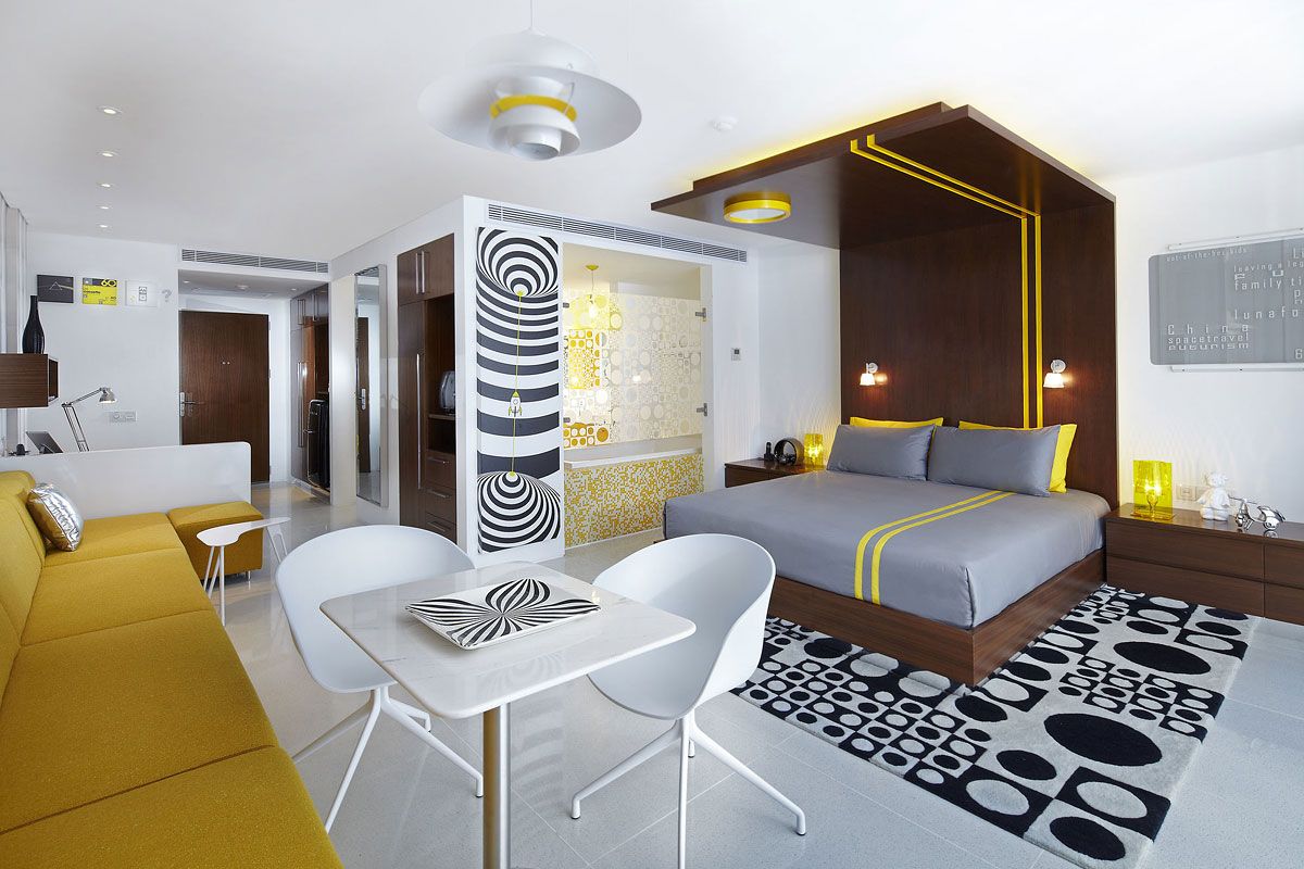 Luna2 Private Hotel in Kuta room with king bed, mustard sofa, and patterned decor
