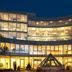 Amadeo Hotel Schaffenrath in Salzburg at night, with a curved glass facade glowing warmly