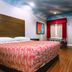 Palace Inn I-10 & John Ralston in Houston room with king bed, desk, and red window curtains