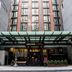 Archer Hotel New York entrance in New York with glass canopy and tall brick facade
