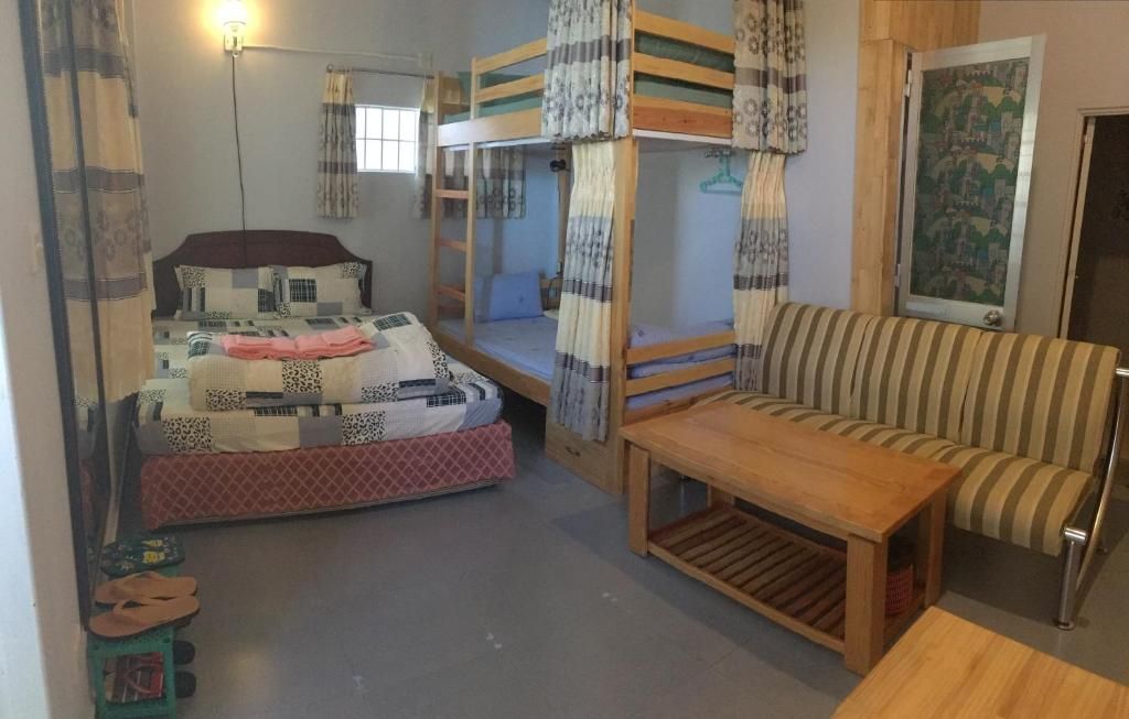 Cherry Balcony in Dalat: cozy room with double bed, bunk bed, striped sofa, and wooden table