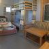 Cherry Balcony in Dalat: cozy room with double bed, bunk bed, striped sofa, and wooden table