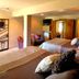 Swan River Inn in Bigfork guest room with two beds, armchair, and wood wardrobe