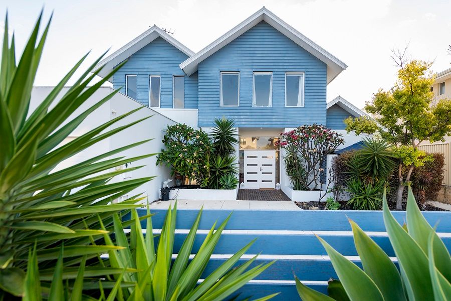 Burns Beach Bed & Breakfast in Perth with a blue exterior, landscaped garden, and poolside deck