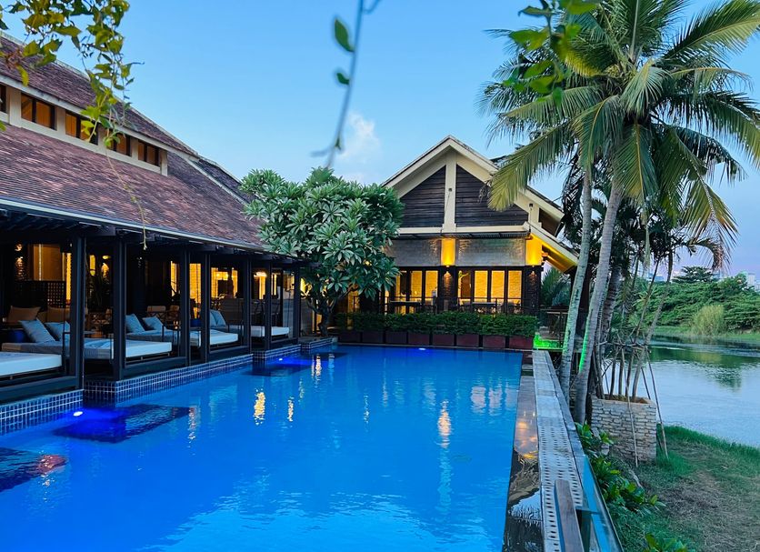 The Blossom Resort Island in Da Nang, a 5-star resort with tropical gardens, a swimming pool, and low-rise buildings by the water