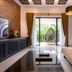 THE BLOSSOM RESORT ISLAND in Da Nang living room with balcony and hanging chair overlooking greenery