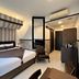THE BLOSSOM RESORT ISLAND in Da Nang guest room with striped canopy bed and seating area