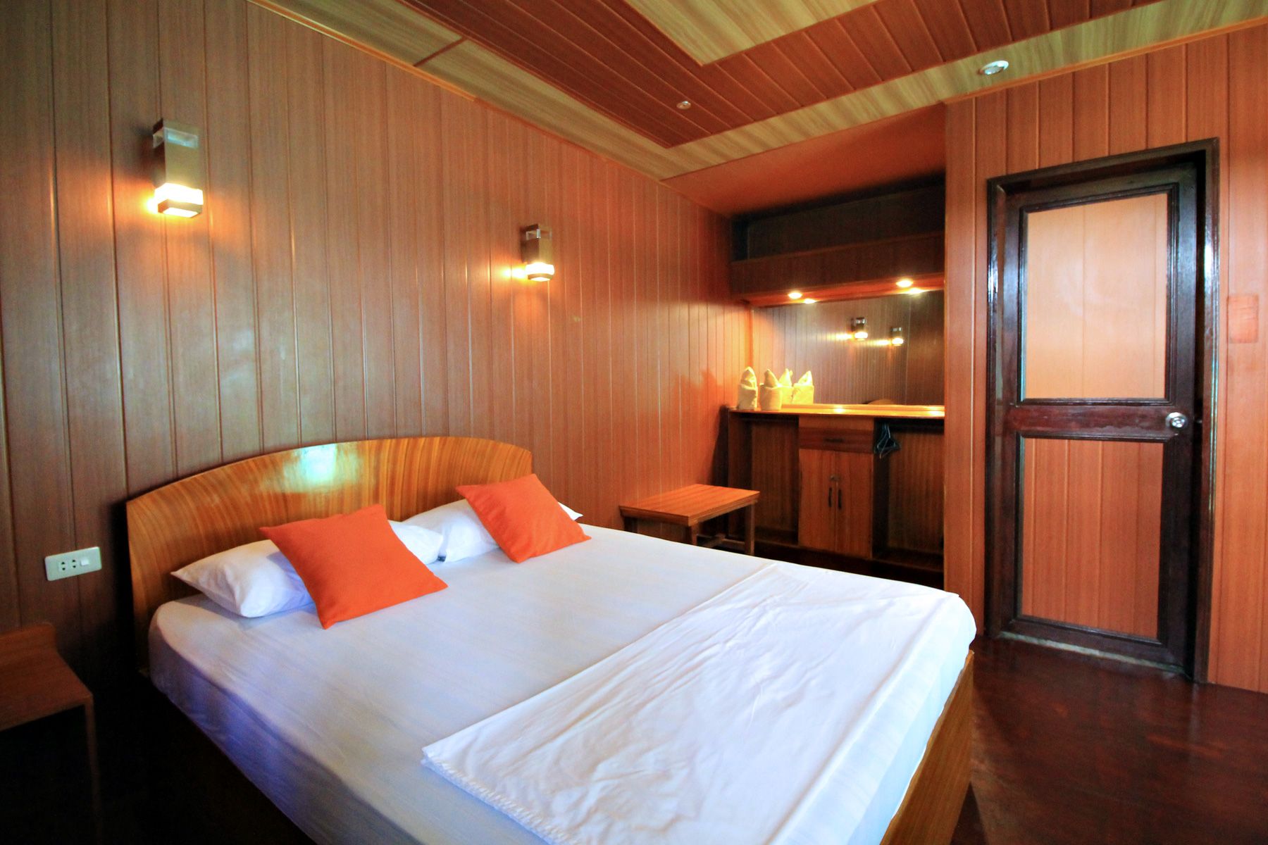 Frendz Hostel Boracay in Boracay room with double bed, wood-paneled walls and small vanity area