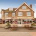 The Hussar in Margate, exterior view of a brick hotel with outdoor picnic tables and a sunny sky.