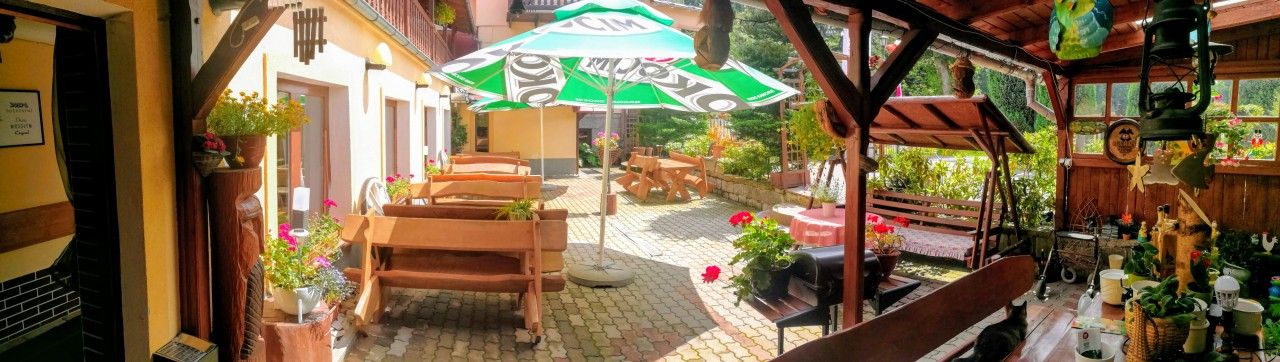 Rezydencja Pod Szczytami in Szklarska Poręba with a cozy outdoor patio, tables, chairs, and potted flowers