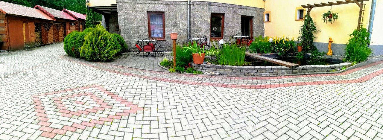 Rezydencja Pod Szczytami in Szklarska Poręba with landscaped courtyard, pavers, and outdoor seating