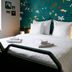 Myö Hostel in Helsinki room with double bed, floral accent wall, bedside lamp and window seat