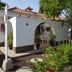 Parque Golf Bungalows in Maspalomas: white bungalow with terracotta roof, arched patio and palm trees