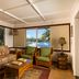 Hana Kai Maui in Hana room with tropical sofa seating and ocean view through large windows