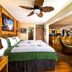 Hana Kai Maui in Hana guest room with bed, ceiling fan, and open view to kitchen and lanai