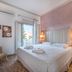 Argyro Rent Rooms in Kritsa guest room with double bed, balcony doors, and pastel pink wall
