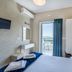 Argyro Rent Rooms in Kritsa bedroom with balcony sea view and blue curtains