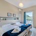Argyro Rent Rooms in Kritsa bedroom with twin beds and a balcony view of hills and sea
