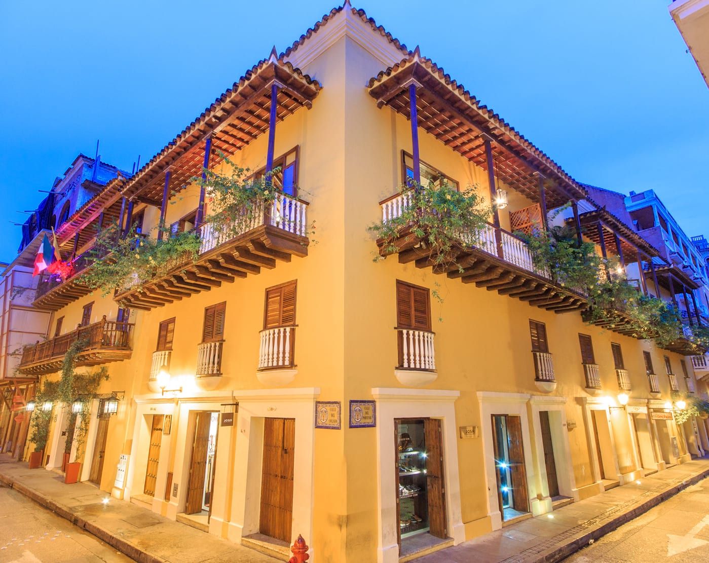 Hotel Boutique Casa del Coliseo in Cartagena, corner facade with balconies and warm-lit street level