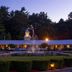 Colonel Williams Resort and Suites in Lake George with fountain and lit courtyard at dusk