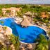 Bahia Principe Explore Turquesa in Punta Cana features a large lagoon-style pool with palm trees and thatched huts