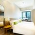 Hotel Ease Access Wan Chai guest room in Hong Kong with bed, TV, window view and bedside lamp
