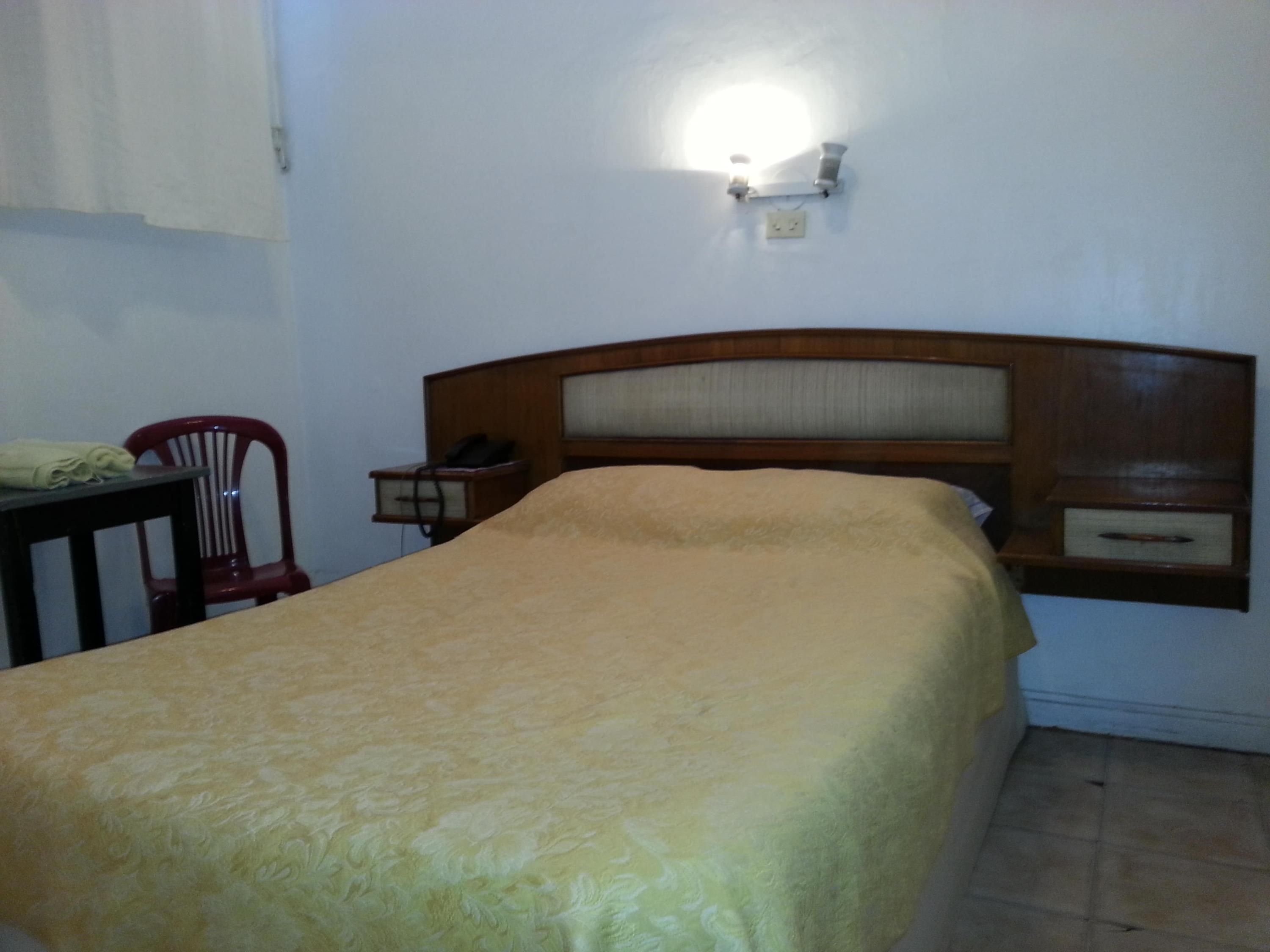 Hotel Isis in Buenos Aires guest room with double bed, wall-mounted light, and simple furnishings