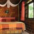 Pousada do Oasis in Morretes bedroom with brick walls, four-poster bed, pink curtains and forest view