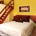 Berna Hotel & Spa room in Villa General Belgrano with wooden staircase beside a neatly made bed
