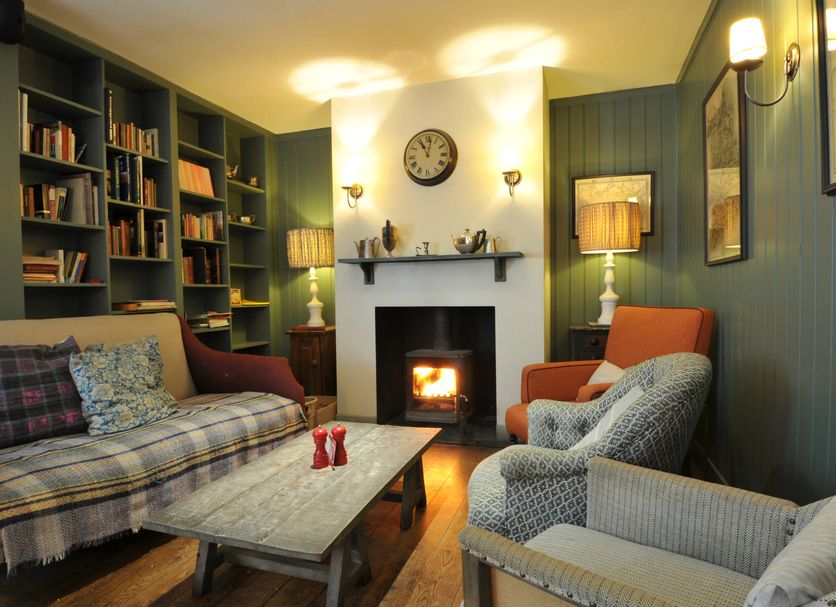 Bel And The Dragon-Churt in Farnham lounge with fireplace, armchairs, bookshelves and coffee table
