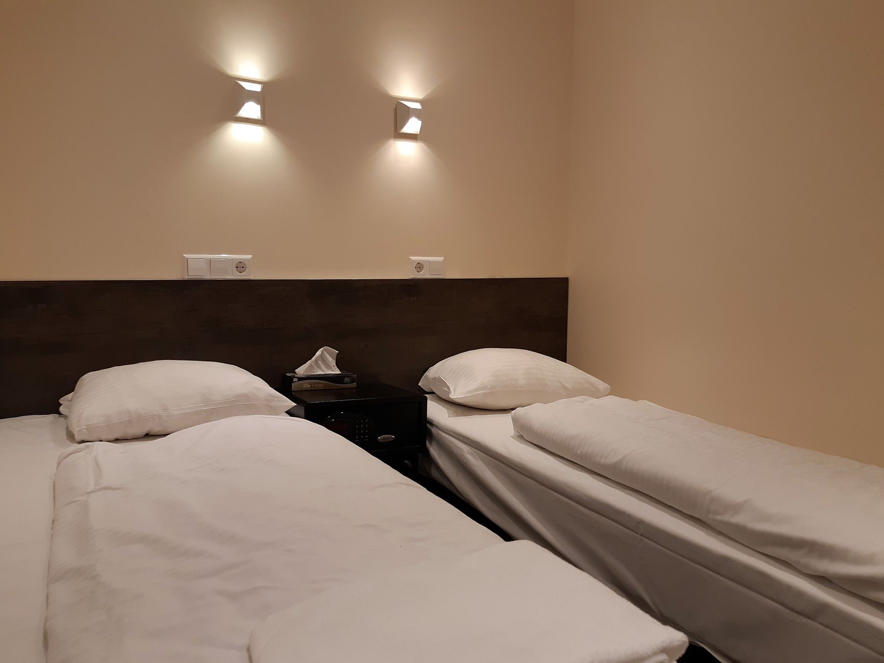 Budget Dam Hotel Amsterdam twin room with two single beds and wall-mounted lights