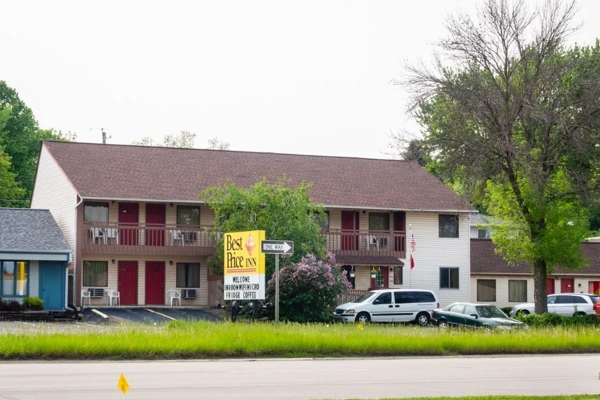 Best Price Inn in Rochester exterior with two-story motel building, parking lot, and roadside sign