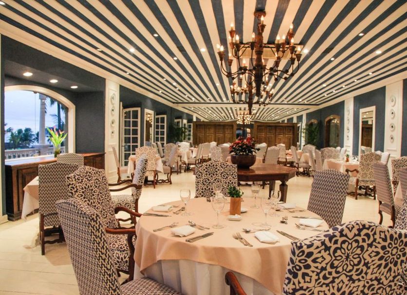 Casa Grande Hotel Resort & Spa dining room in Guarujá with round tables, chandeliers and striped ceiling