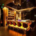 Howard Johnson by Wyndham Parkland Hotel Dalian bar with lit counter, stools, and bottle display