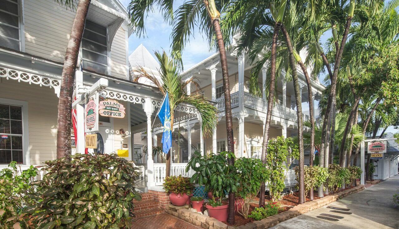 The Palms Hotel in Key West with palm trees, lush landscaping, and a charming porch