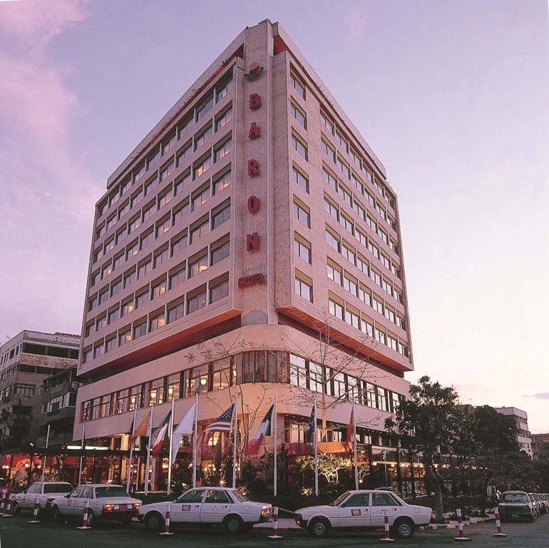 Baron Hotel Cairo tower in Cairo at dusk, with street-level entrance and parked cars