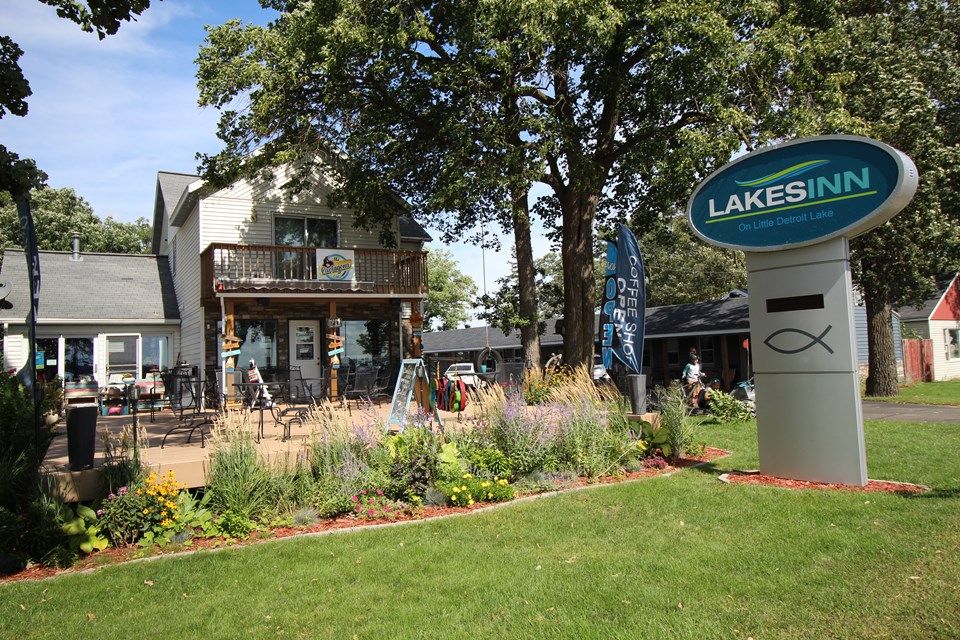 Lakes Inn in Detroit Lakes exterior with balcony, garden landscaping, and sign in front