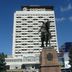 Hotel Cosmos in Chisinau with a tall facade behind an equestrian statue under a blue sky