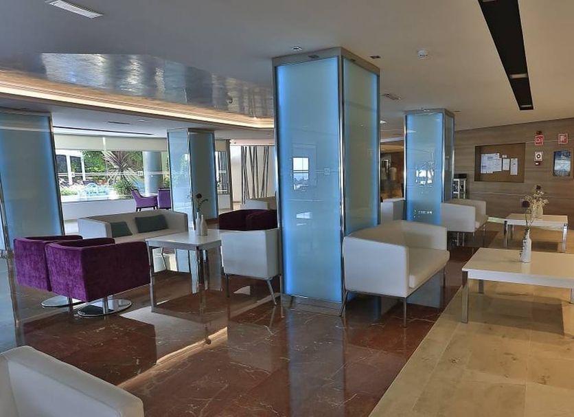 Hotel Agua Beach Adults Only in Palma Nova lobby lounge with white seating and floor-to-ceiling glass columns