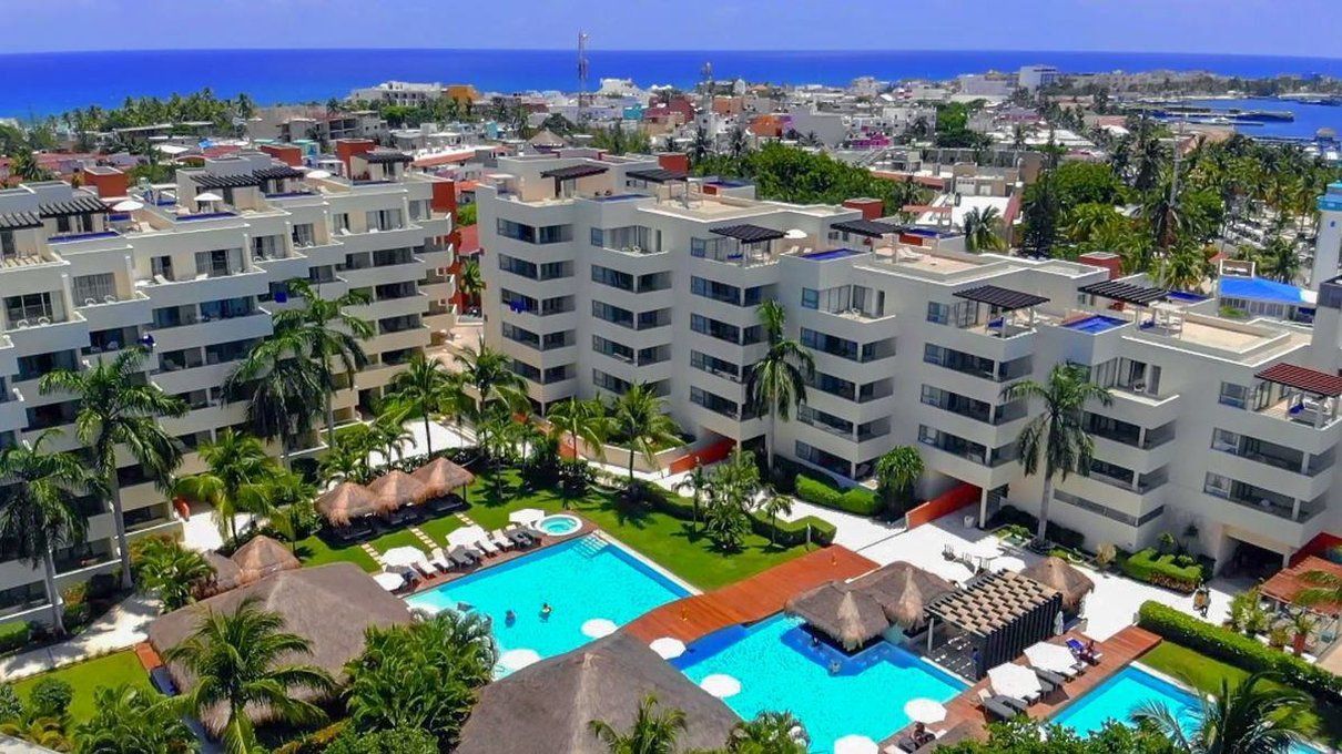 Privilege Aluxes Adults Only in Isla Mujeres with pools, palm trees, and ocean views from a rooftop scene